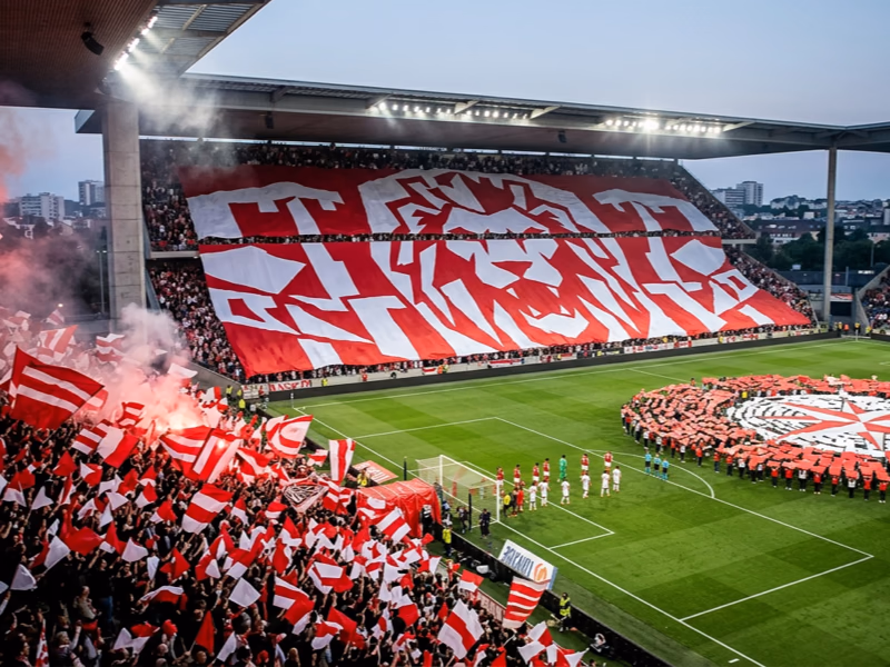 Tifos foot déployés en tribune et sur pelouse pendant un match de Ligue 1
