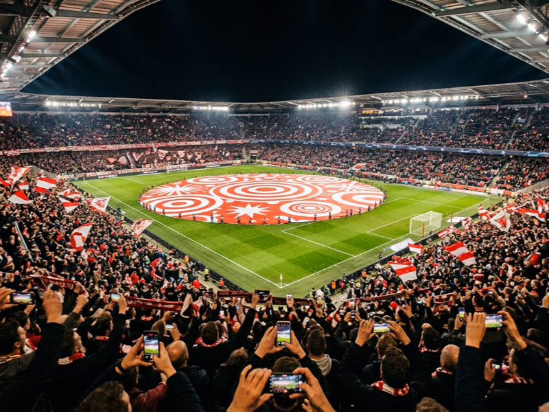 Vue depuis tribune d'un tifo rond central déployé sur pelouse